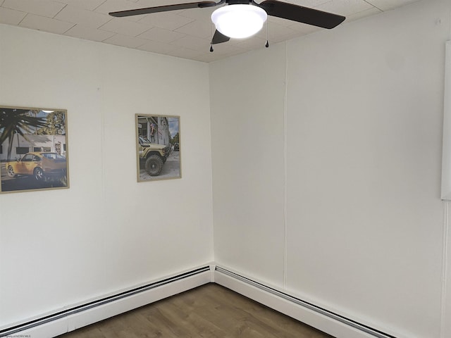 spare room with ceiling fan, a baseboard heating unit, and hardwood / wood-style floors