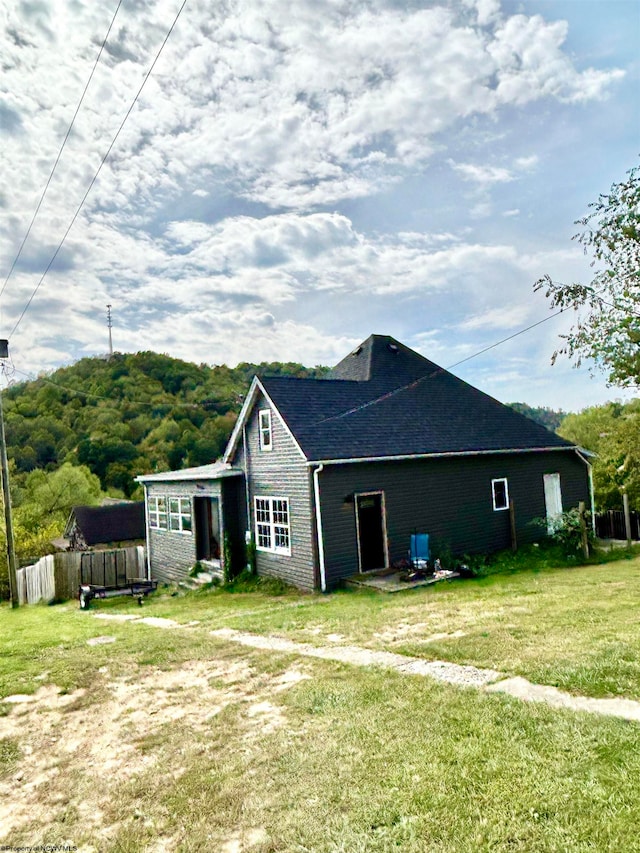 rear view of property with a lawn