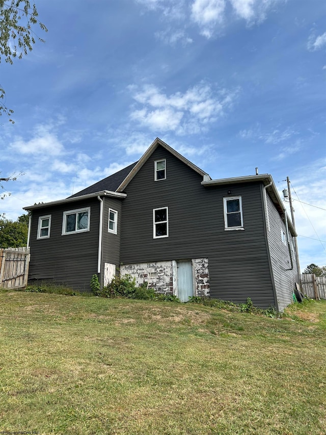 rear view of house featuring a lawn