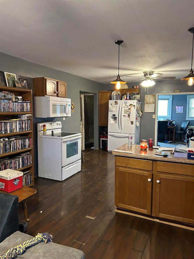 kitchen featuring white appliances, pendant lighting, and dark hardwood / wood-style floors