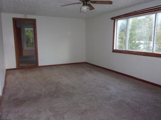 unfurnished room with a textured ceiling, carpet flooring, and ceiling fan