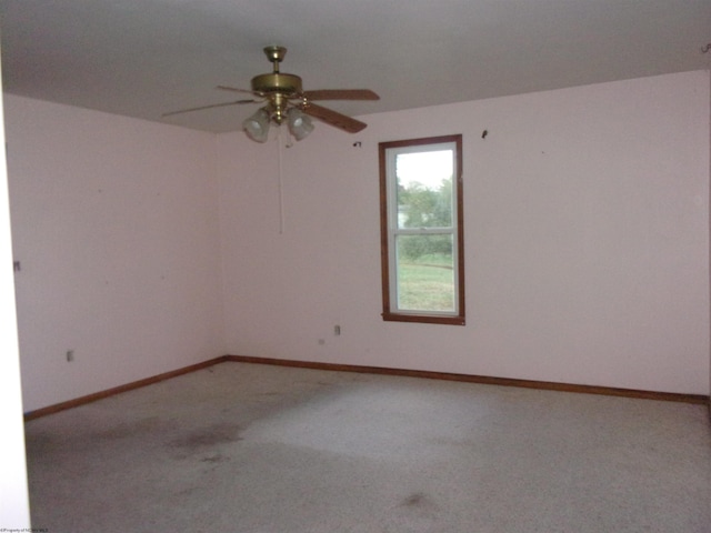 carpeted spare room featuring ceiling fan