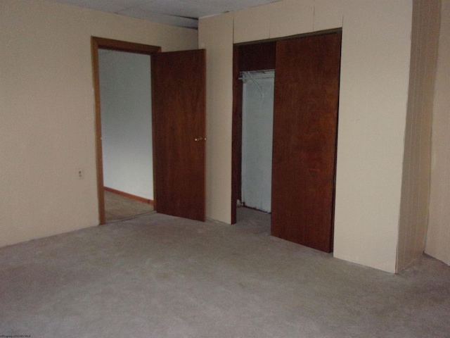 unfurnished bedroom featuring light carpet and a closet