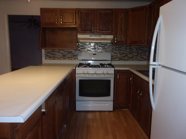 kitchen featuring wood-type flooring, white appliances, ceiling fan, and backsplash