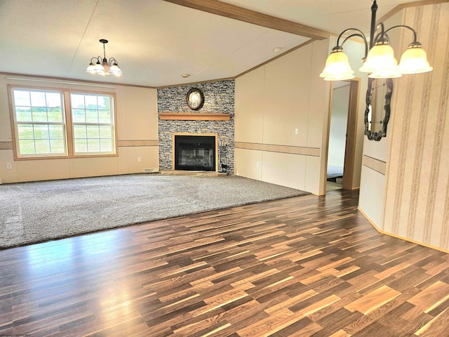 unfurnished living room with a notable chandelier, lofted ceiling, dark hardwood / wood-style floors, and a fireplace