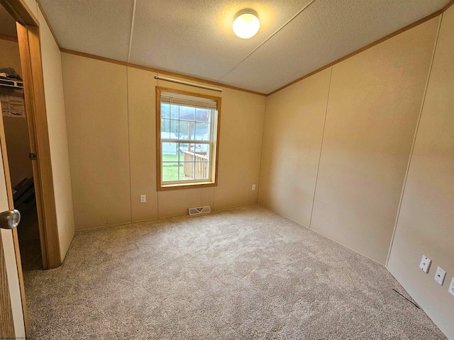 unfurnished bedroom featuring carpet floors, a textured ceiling, and ornamental molding