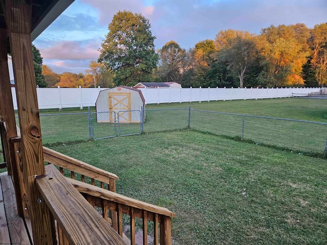 yard at dusk featuring a storage shed