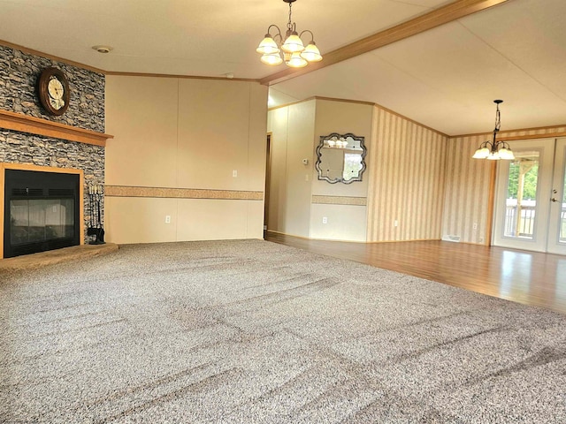 unfurnished living room with vaulted ceiling with beams, wood-type flooring, a stone fireplace, a chandelier, and crown molding