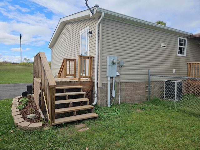 back of property with central AC and a yard