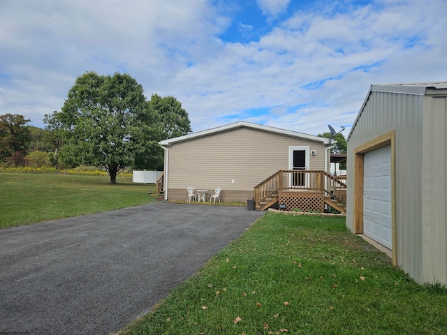 view of side of property with a yard, an outdoor structure, and a garage