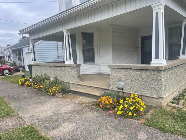 view of exterior entry featuring covered porch