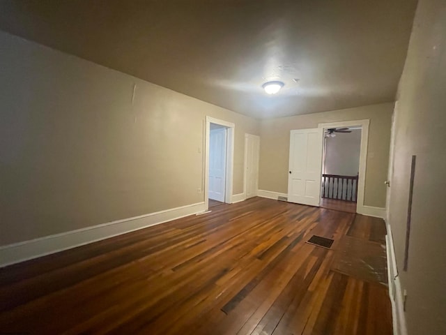 empty room with dark hardwood / wood-style flooring