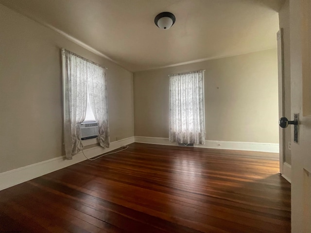 spare room featuring cooling unit and dark hardwood / wood-style floors