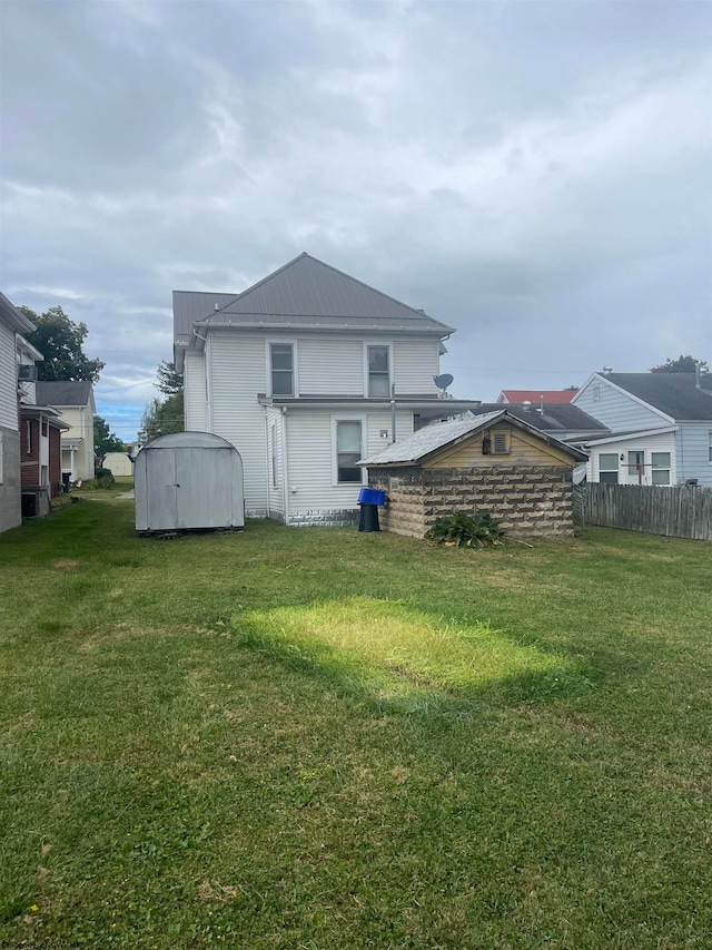 back of house featuring a lawn and a storage unit