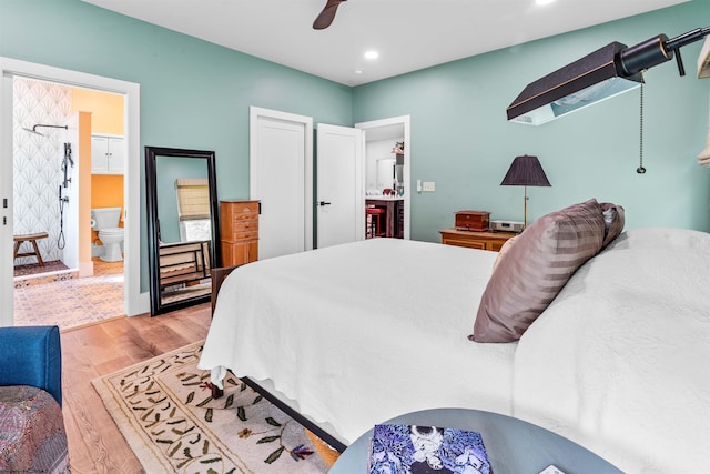 bedroom with ceiling fan, light hardwood / wood-style flooring, and ensuite bath