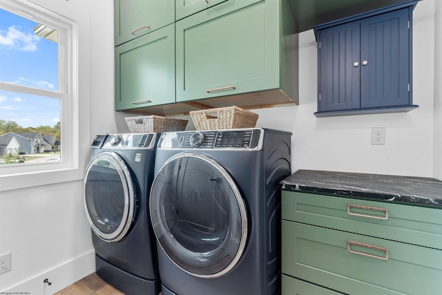 washroom featuring cabinets, light wood-type flooring, and independent washer and dryer