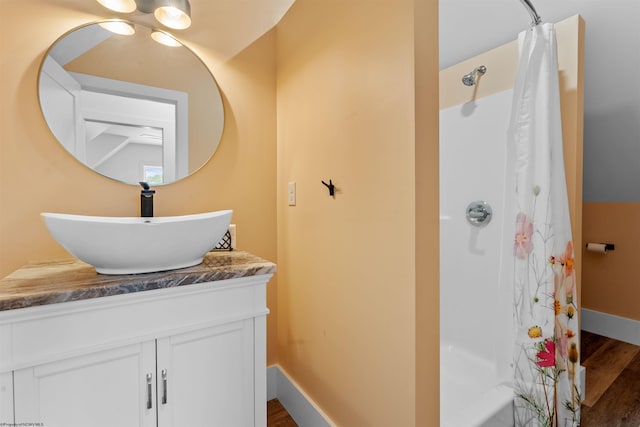 bathroom featuring wood-type flooring, vanity, and shower / bath combo