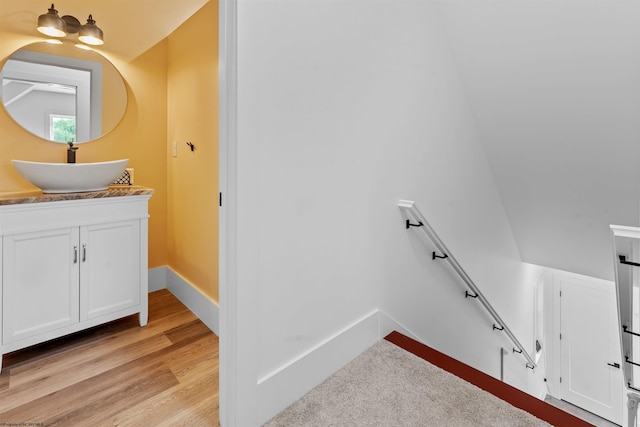 bathroom featuring lofted ceiling, vanity, and hardwood / wood-style flooring