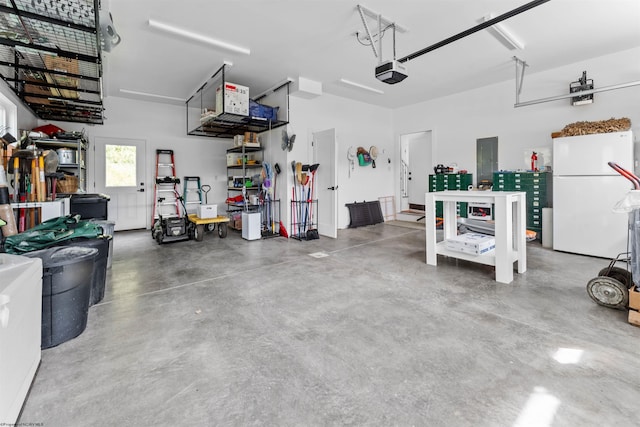 garage with a garage door opener, electric panel, and white fridge