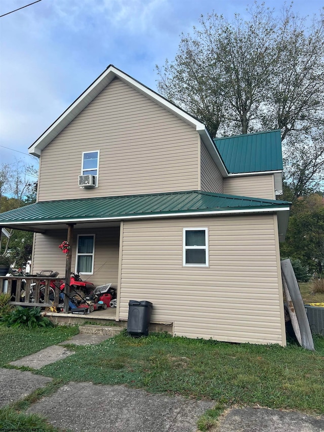 view of side of home featuring metal roof and cooling unit