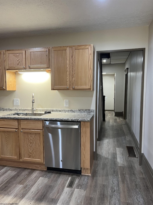 kitchen with a sink, dark wood-style flooring, light countertops, and stainless steel dishwasher