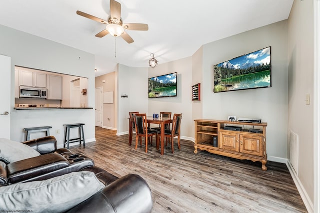 living room with wood-type flooring and ceiling fan