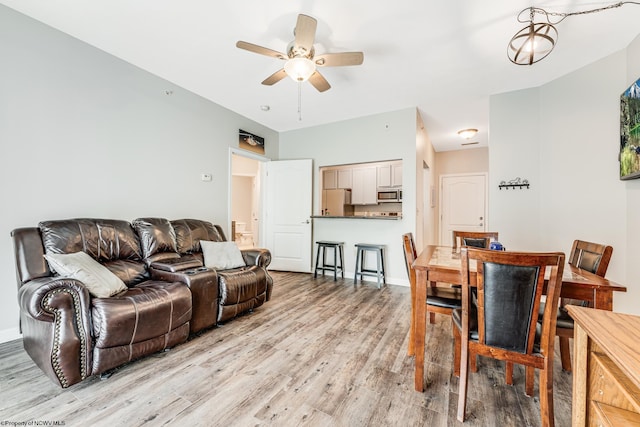 living room with light hardwood / wood-style flooring and ceiling fan