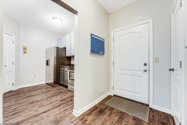 entryway with a textured ceiling and hardwood / wood-style flooring