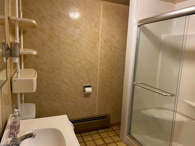 bathroom featuring toilet, a baseboard heating unit, and a shower with shower door