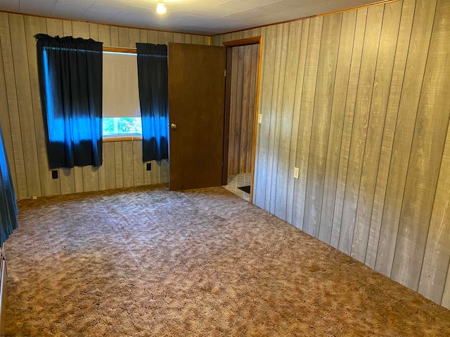 carpeted empty room with wooden walls