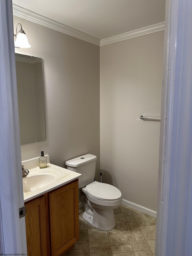 bathroom with ornamental molding, vanity, and toilet