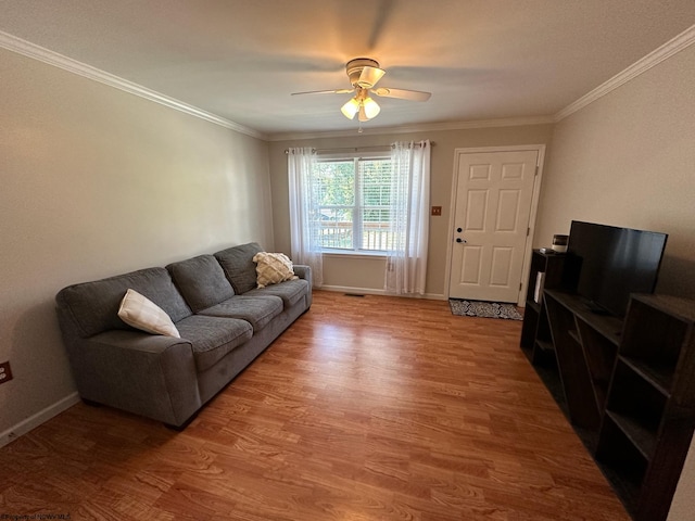 living room with wood-type flooring, ornamental molding, and ceiling fan