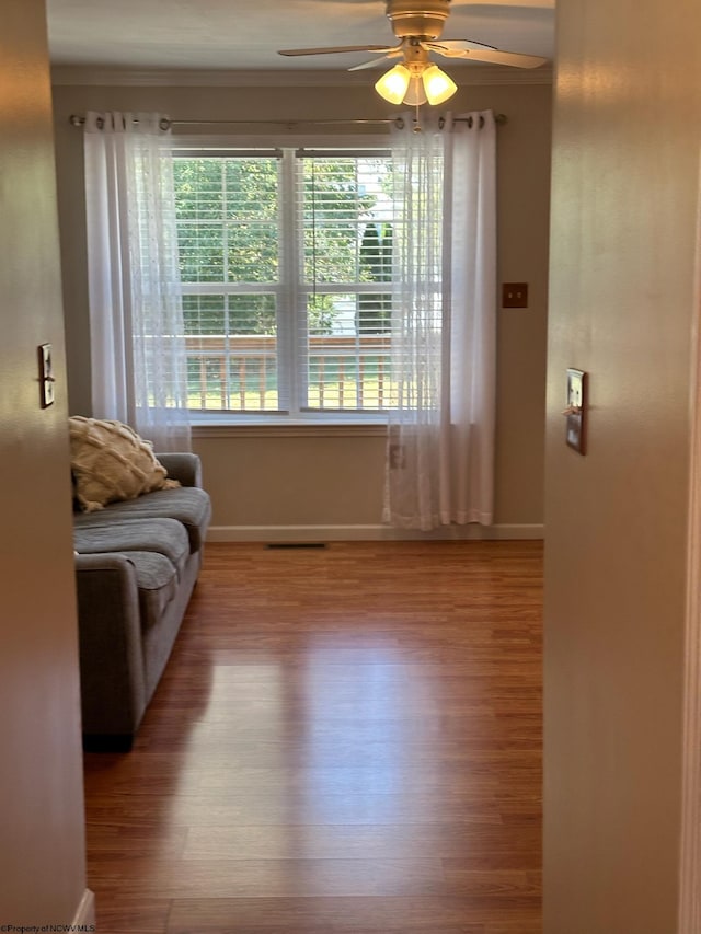 living area with ornamental molding, ceiling fan, and hardwood / wood-style flooring