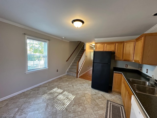 kitchen with black fridge, white dishwasher, crown molding, and sink