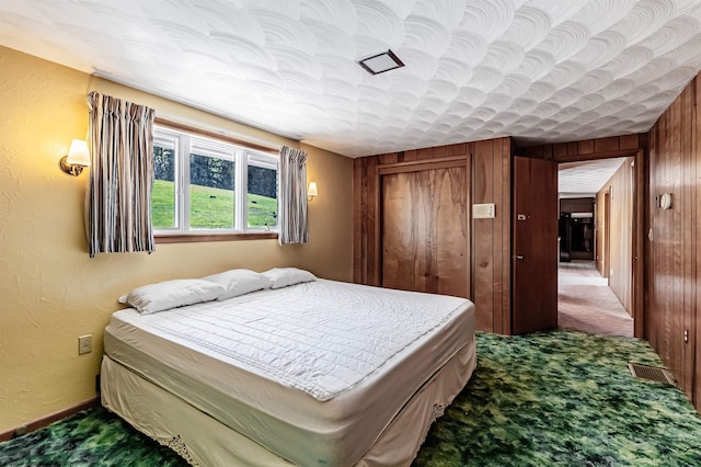 bedroom featuring carpet floors and wooden walls