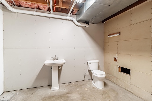 bathroom with concrete floors, sink, and toilet