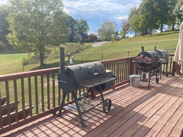 wooden terrace featuring a grill and a yard