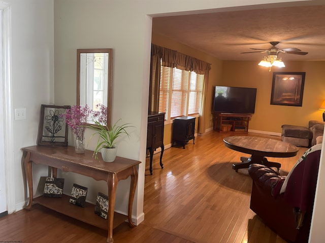 living room featuring light wood-type flooring and ceiling fan