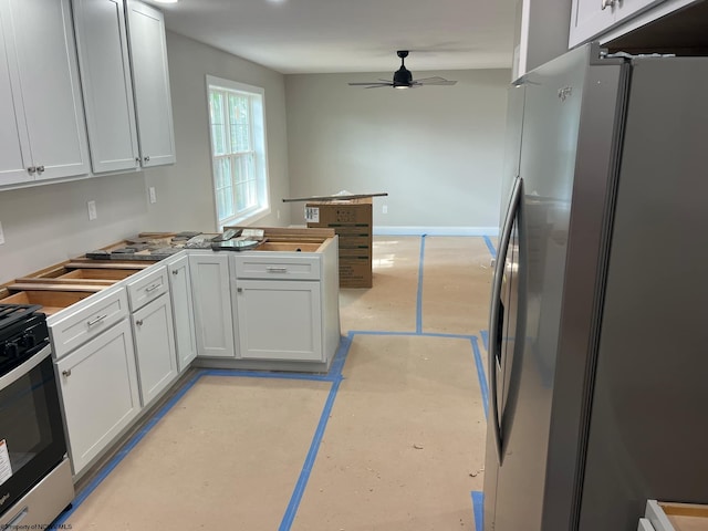 kitchen featuring stainless steel fridge, range with gas stovetop, ceiling fan, and white cabinets