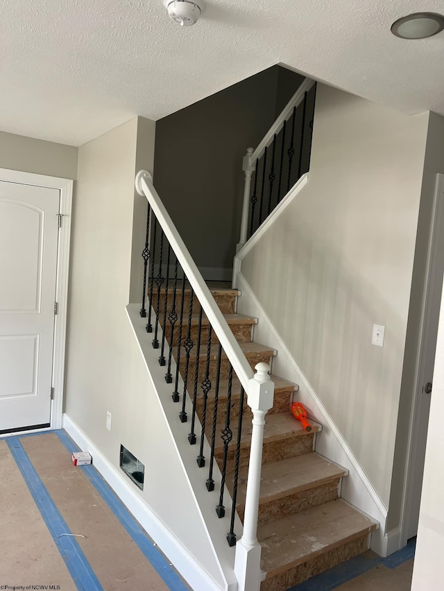 stairway with a textured ceiling