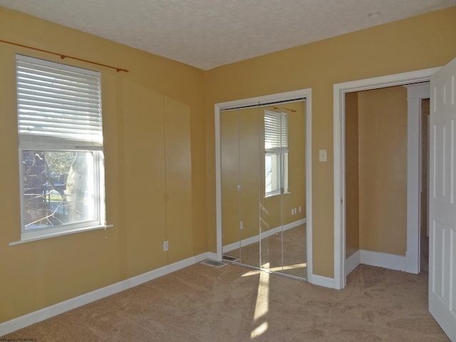 unfurnished bedroom featuring light carpet and multiple windows