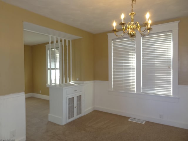 interior space with light carpet and a chandelier