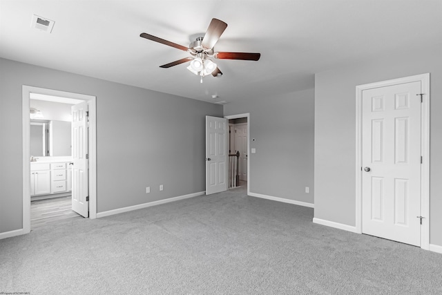 unfurnished bedroom with light carpet, ensuite bath, and ceiling fan