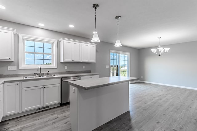 kitchen featuring a center island, sink, white cabinets, hanging light fixtures, and stainless steel dishwasher