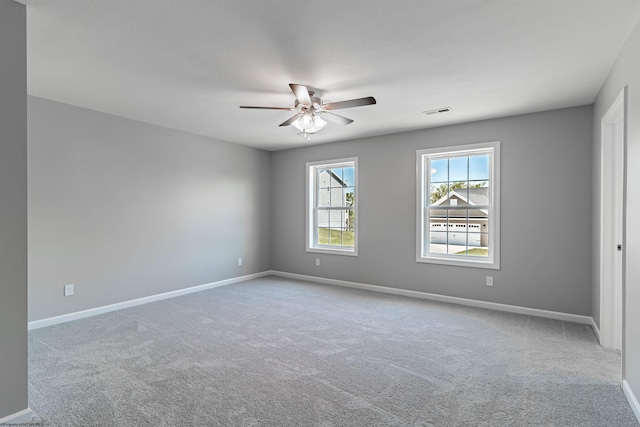 carpeted spare room featuring ceiling fan