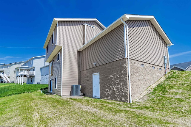 view of side of property with a lawn and central AC unit