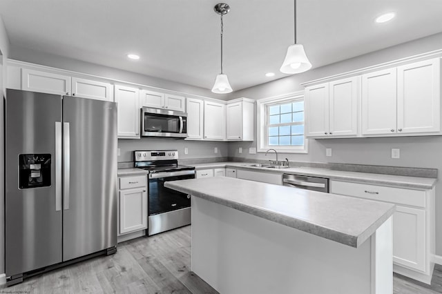 kitchen with appliances with stainless steel finishes, light hardwood / wood-style floors, and white cabinetry