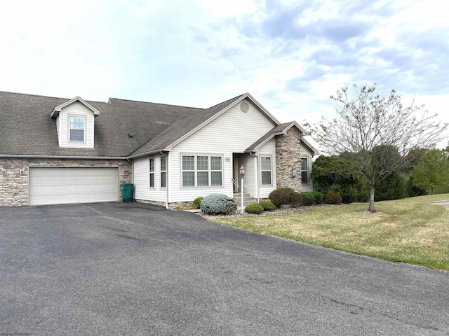 view of front facade with aphalt driveway, stone siding, a shingled roof, a front yard, and a garage