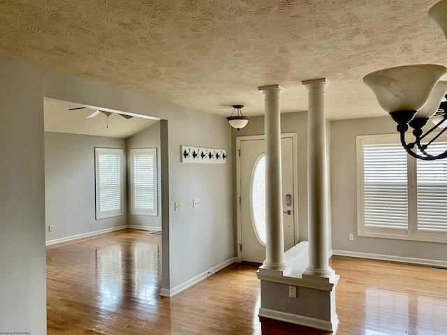 entrance foyer with ceiling fan with notable chandelier, wood finished floors, and baseboards