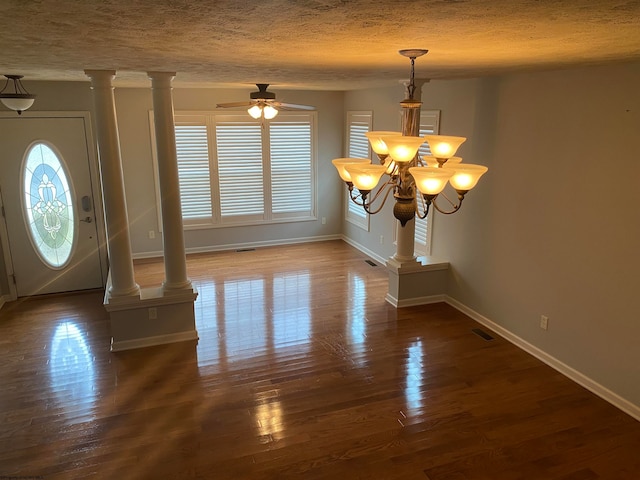 foyer featuring a textured ceiling, ceiling fan with notable chandelier, decorative columns, and dark hardwood / wood-style flooring